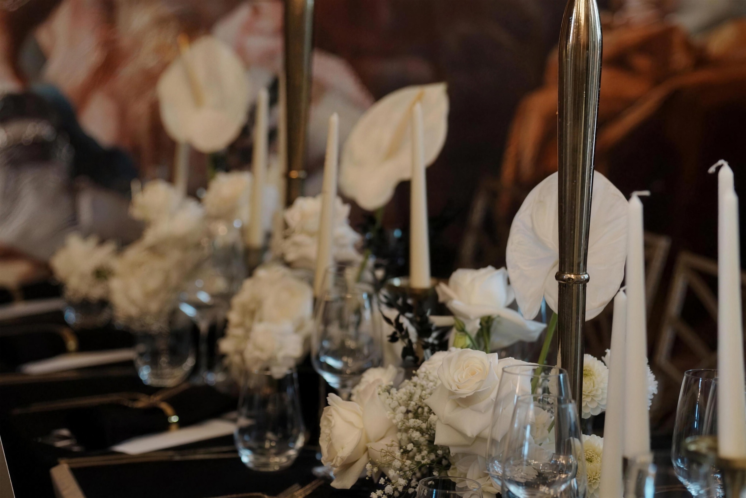 Black-tie tablescape with white anthurium and taper candles