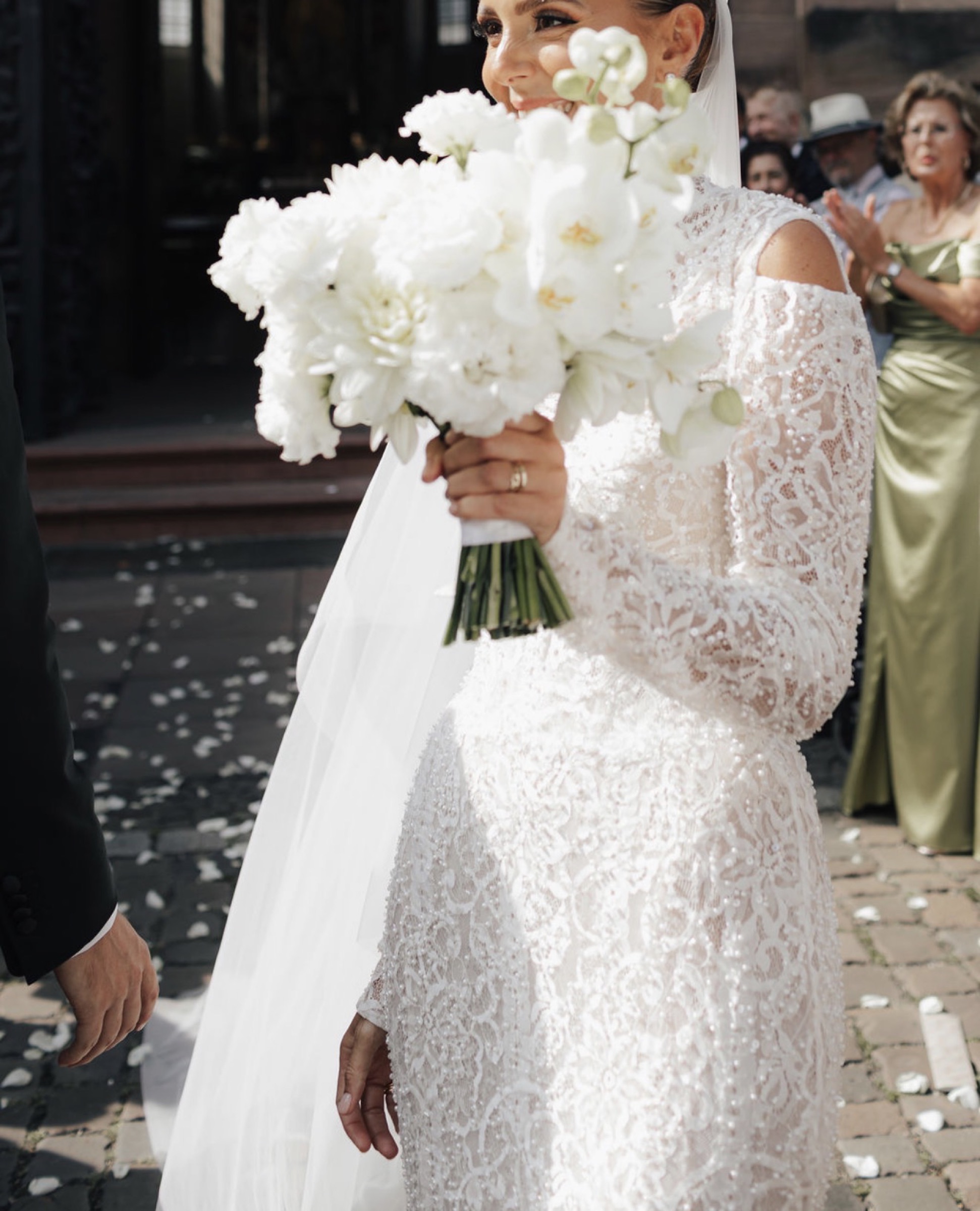 Bridal bouquet of white orchids against a lace gown